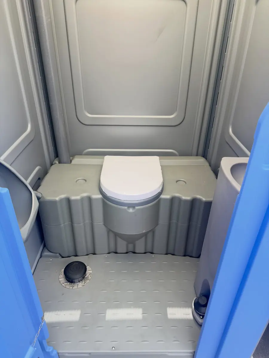 Freshly serviced porta potty interior with clean seat and floor