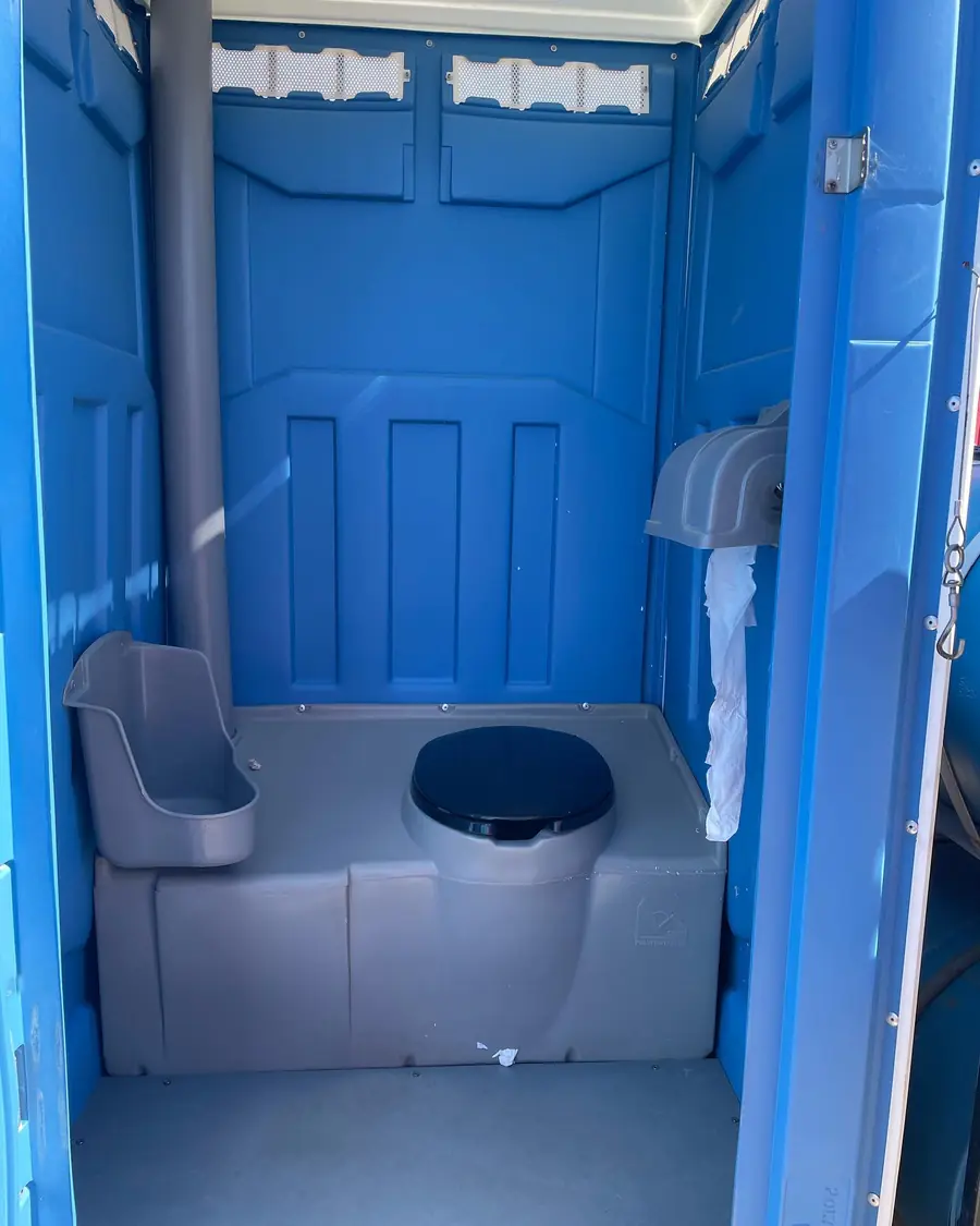 Standard porta potty interior with urinal, seat and toilet paper