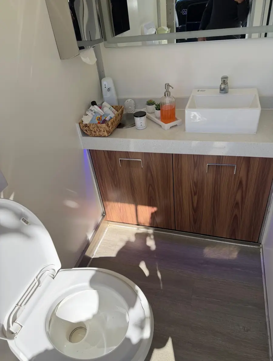 Luxury restroom trailer vanity with wood cabinets and vessel sink