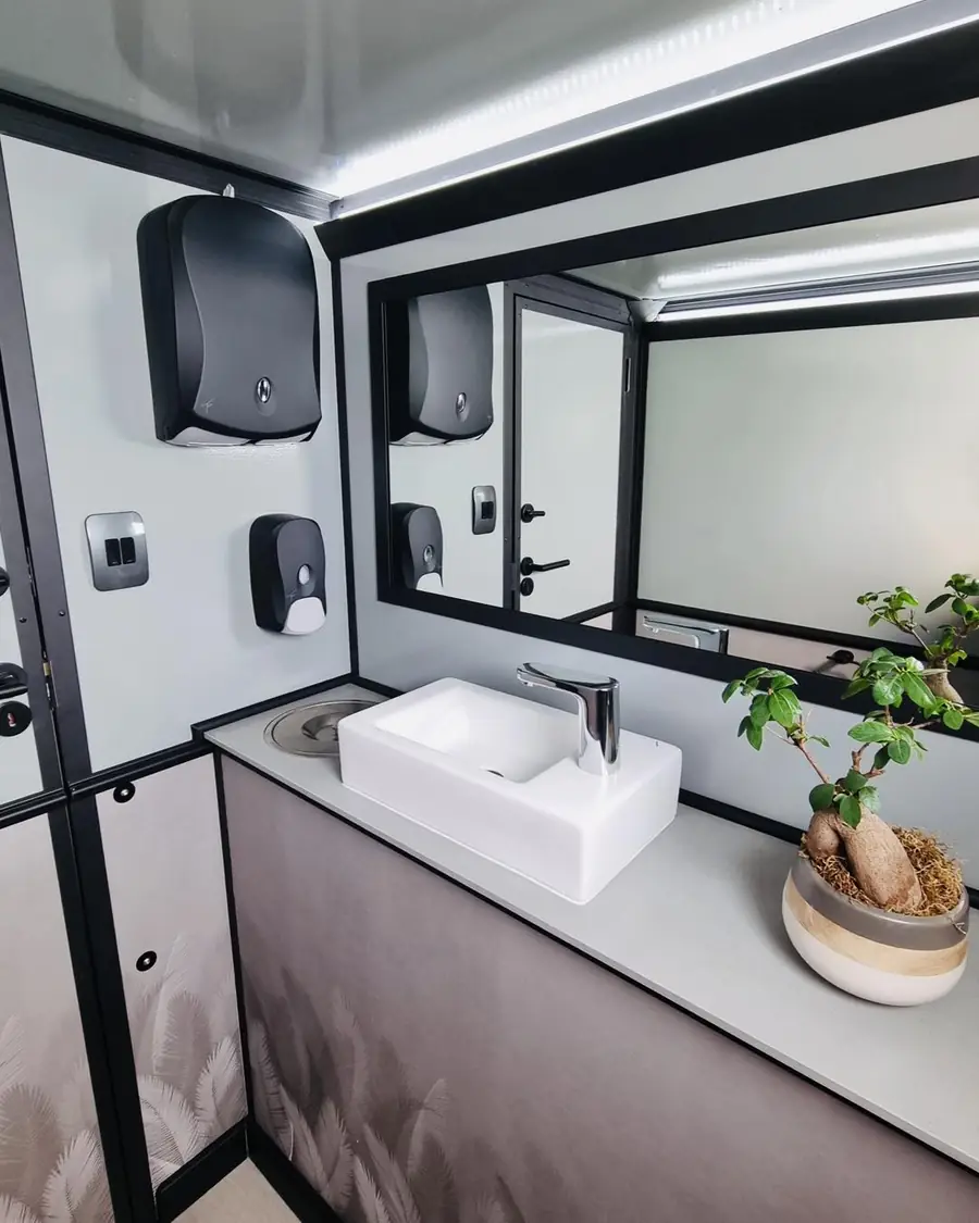 Restroom trailer vanity with vessel sink, mirror and soap dispensers