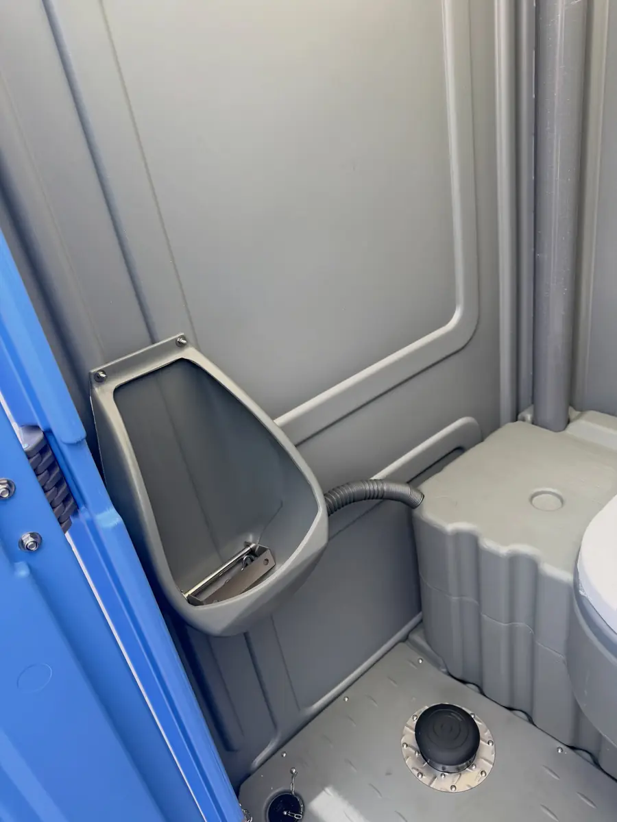 Porta potty interior showing urinal and anti-slip floor